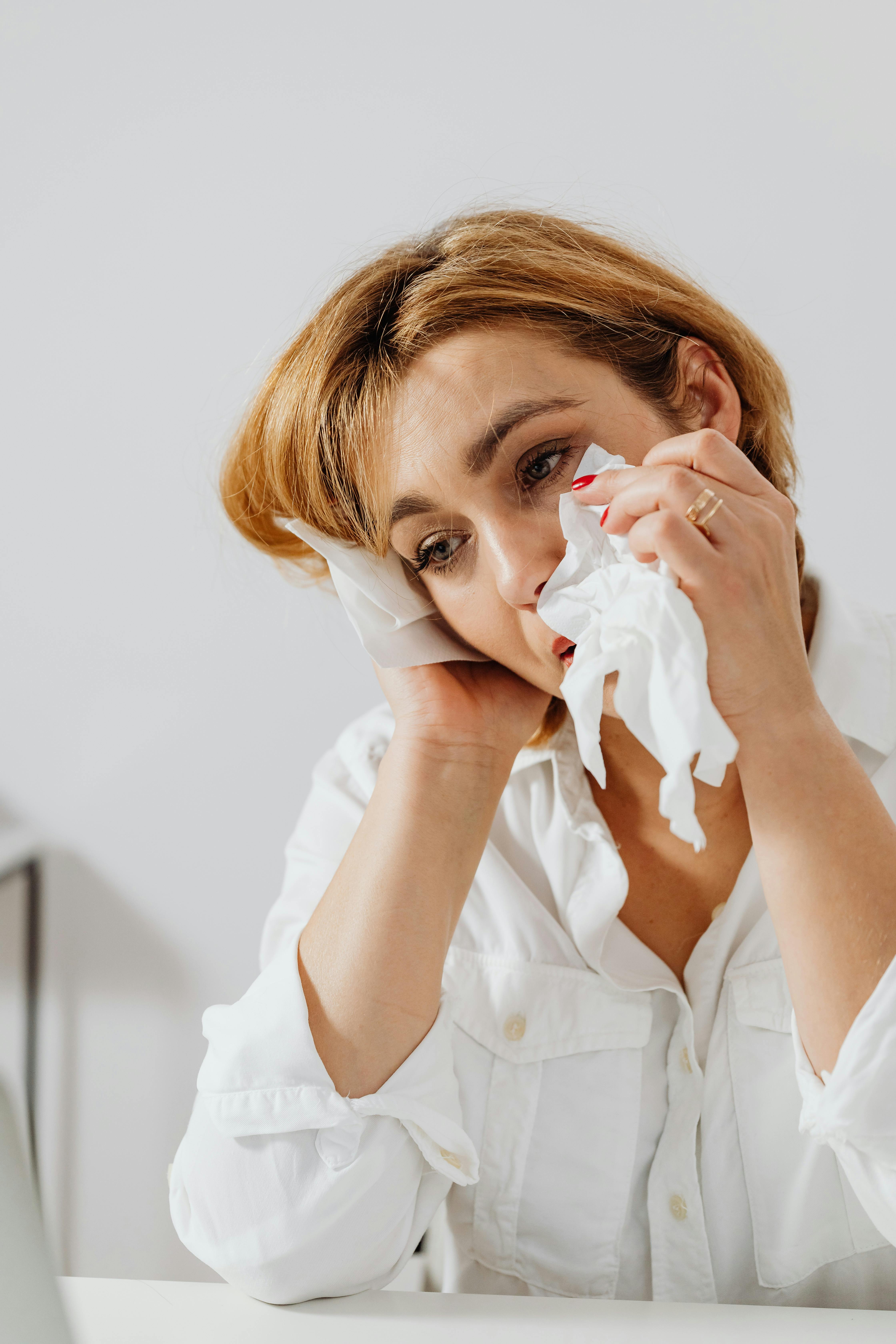 a sad woman wiping her tears with tissue