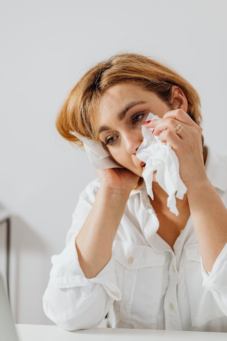 A Sad Woman Wiping Her Tears With Tissue