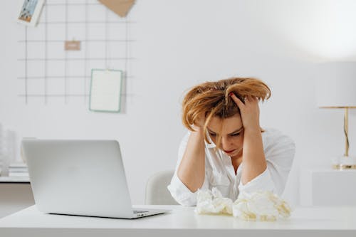Free A Woman in White Long Sleeves Looking Stressed Stock Photo