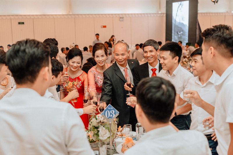 Guests raising glasses together in a toast at a wedding reception