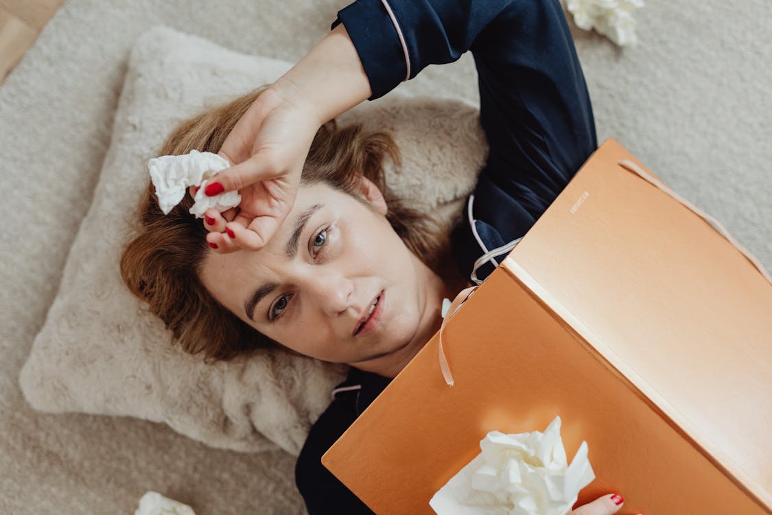 Free Woman Lying while Holding Crumpled Tissue Stock Photo