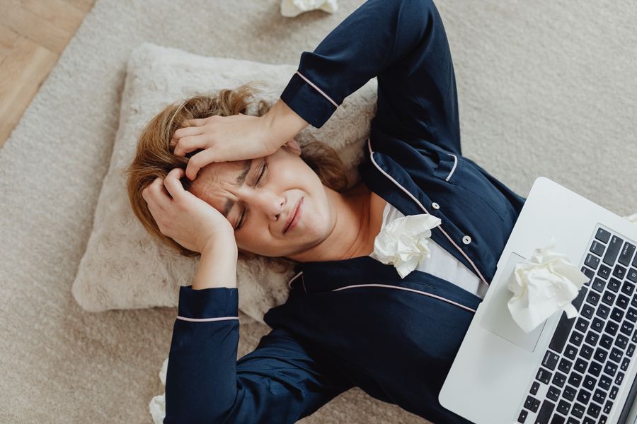 A frustrated person at a laptop with crumpled papers, illustrating subscription hassles