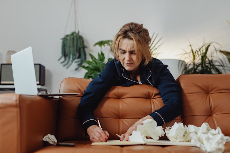 Woman In Blue Pajama Leaning On Orange Couch