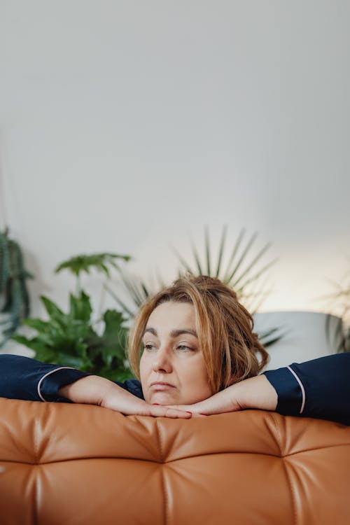 Free Thinking Woman on the Orange Couch Stock Photo