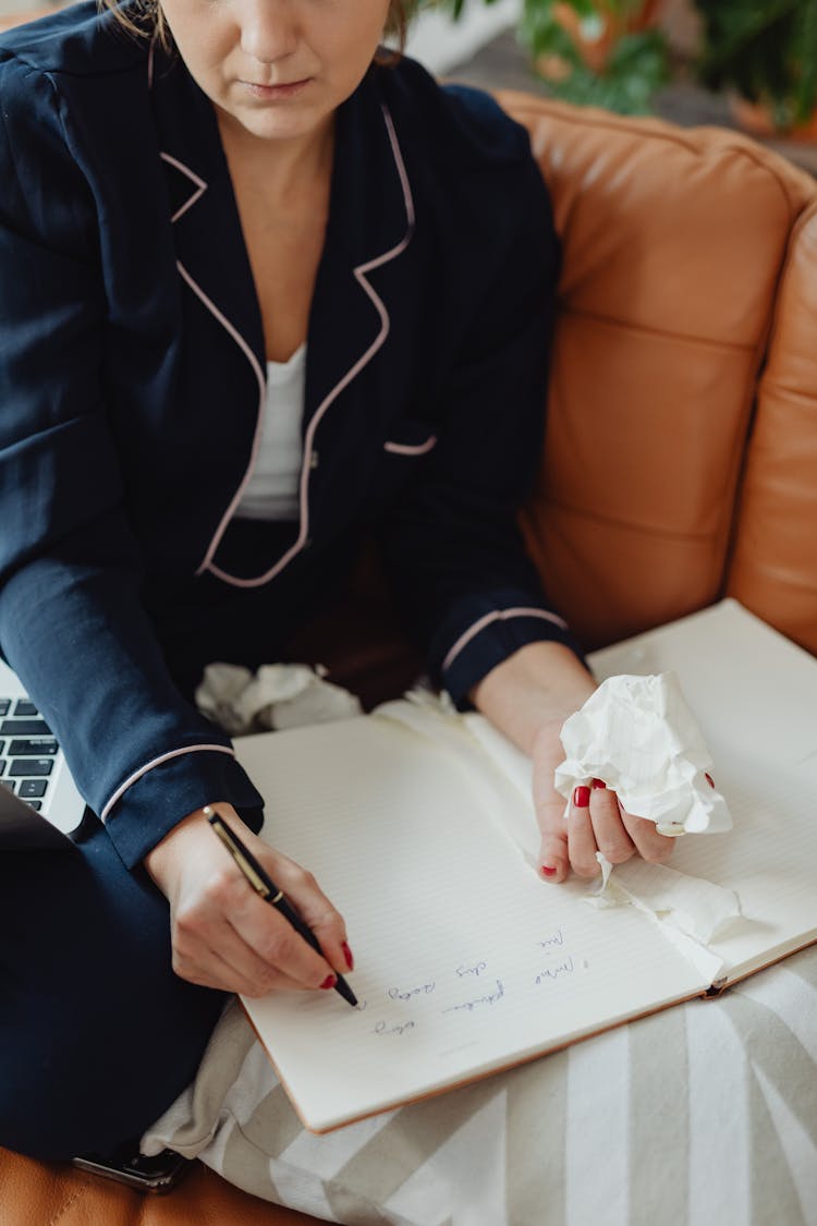 Person In Blue Long Sleeve Shirt Writing On A Big Notebook