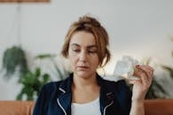 Woman Looking Uneasy Holding a Crumpled Paper