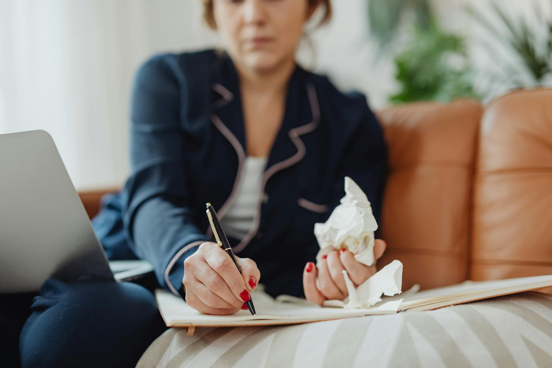 Sick Woman Holding Tissues Writing in Notebook