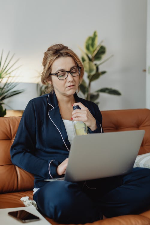 Woman Wearing Blue Pajamas Using a Laptop
