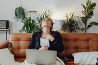 Woman in Blue Long Sleeve Shirt Sitting on Orange Couch
