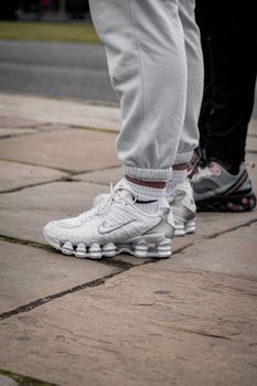 Close-up of trendy sneakers worn outdoors, showcasing street fashion.