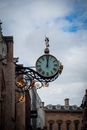 Clock Hanging on the Side of a Building