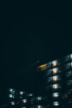 Nighttime photo of a residential building in Breda with lights illuminating the facade against the night sky.