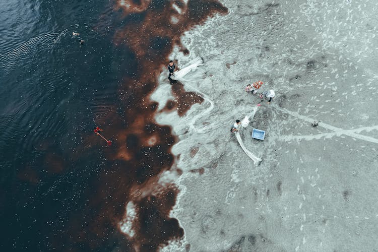 Fishermen Fishing With Net In Troubled Sea Water