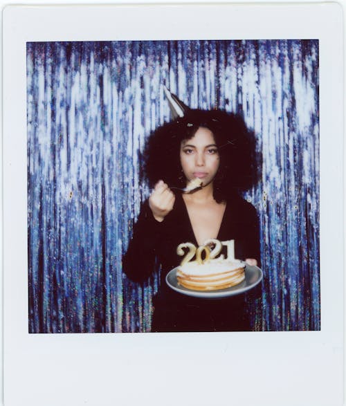 An Instant Photo of a Woman Eating  Cake