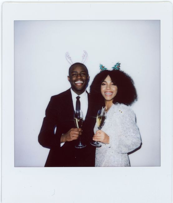 Happy couple in festive attire toasting with champagne, radiating joy and celebration.