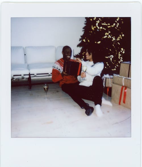 An Instant Photo of a Woman Giving a Gift to a Man