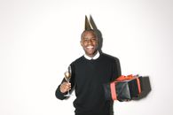 Man in Black V Neck Long Sleeve Shirt Holding Black and Red Bag