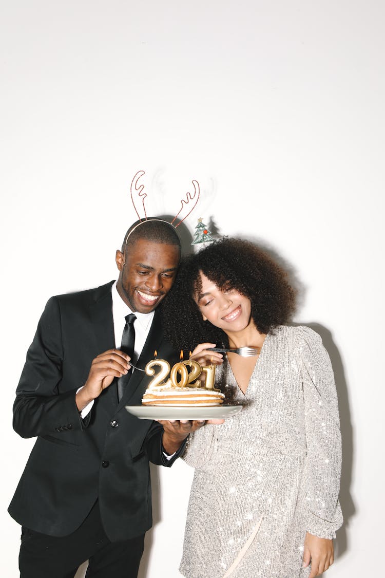 An Elegant Man And Woman Holding Cake