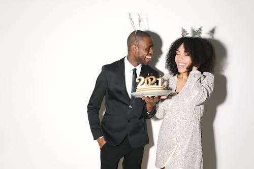 An Elegant Man and Woman Holding Cake