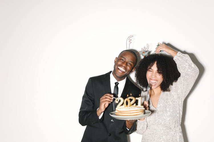 Man And Woman Holding A Ceramic Plate With Cake