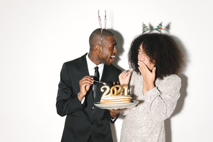 A Man And Woman Holding Cake