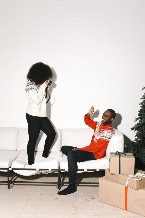 Free Friends celebrating winter holidays indoors with gifts and joy. Stock Photo