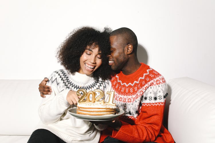 A Man And Woman Holding A Cake