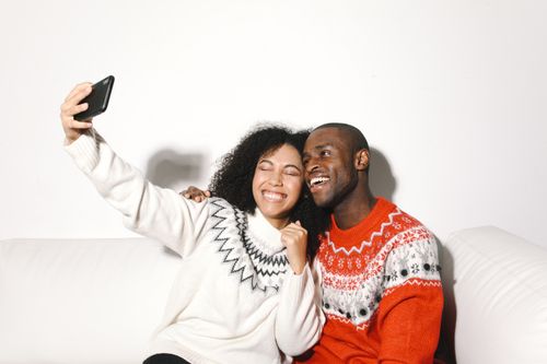 Free Happy couple capturing a joyful moment with a selfie indoors. Stock Photo