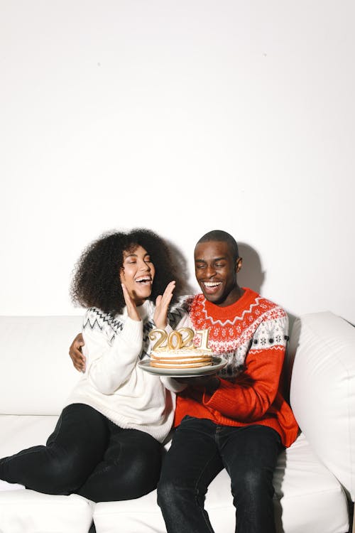 A Couple in Ugly Christmas Sweaters Celebrating New Year
