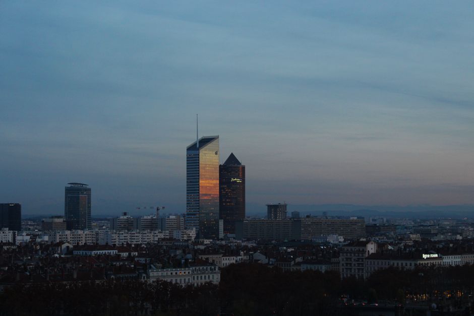 Vue aérienne de la skyline de Lyon mettant en valeur les gratte-ciel contre un ciel au coucher du soleil.