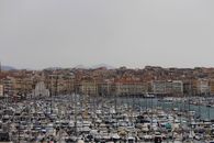 A Harbor Full of Watercrafts Near the City with Congested Buildings