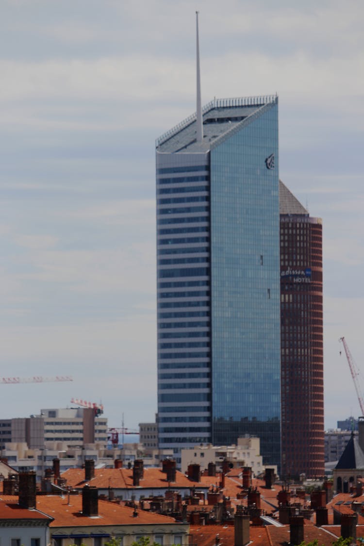 A Blue Rise Glass Building With Slanted Roof Top