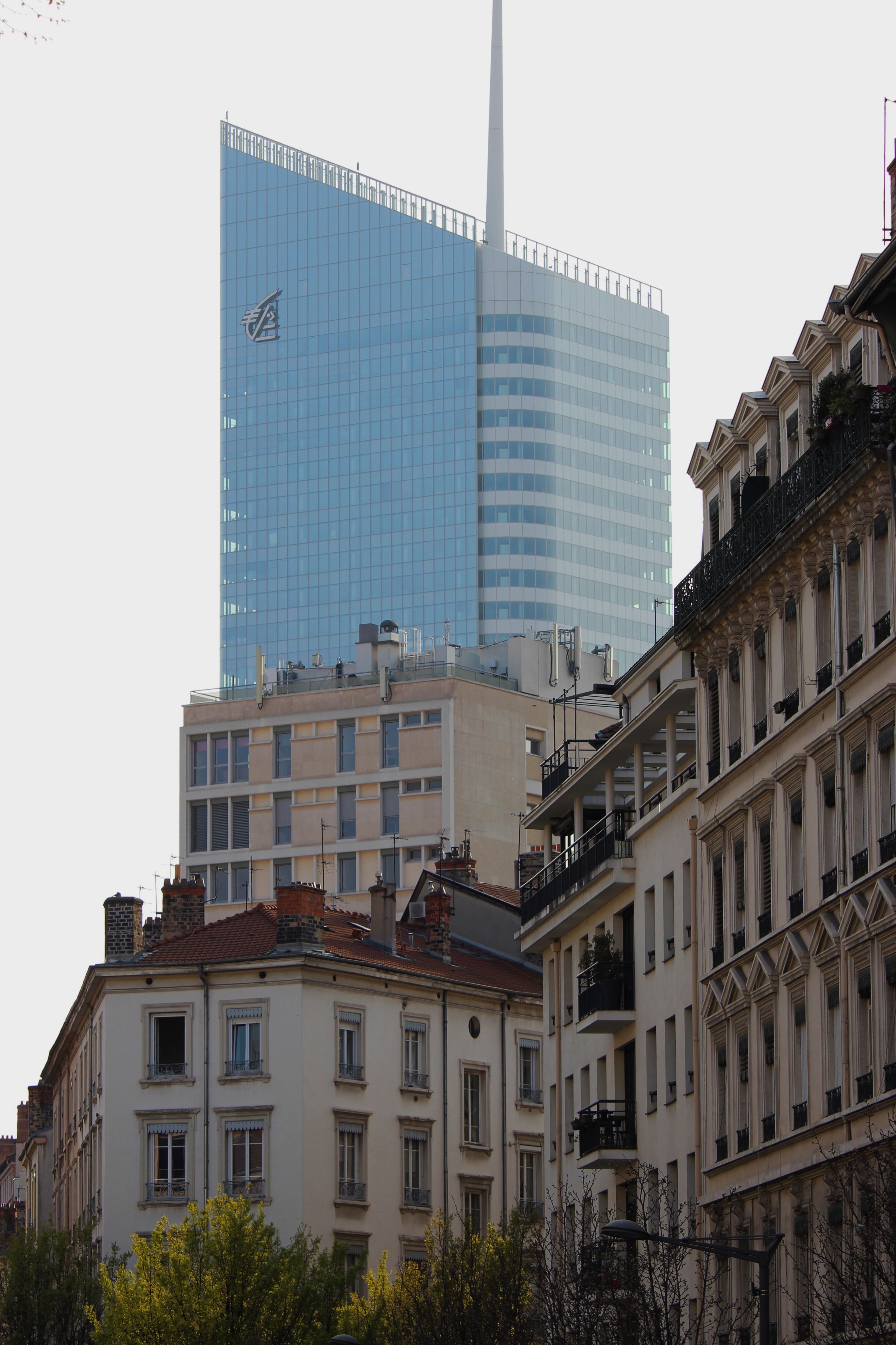 A modern skyscraper rises behind historic city buildings capturing the blend of old and new architecture.