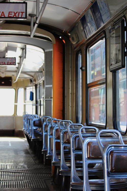 Free A detailed view of the interior of an empty vintage tram with metal railings and empty seats. Stock Photo
