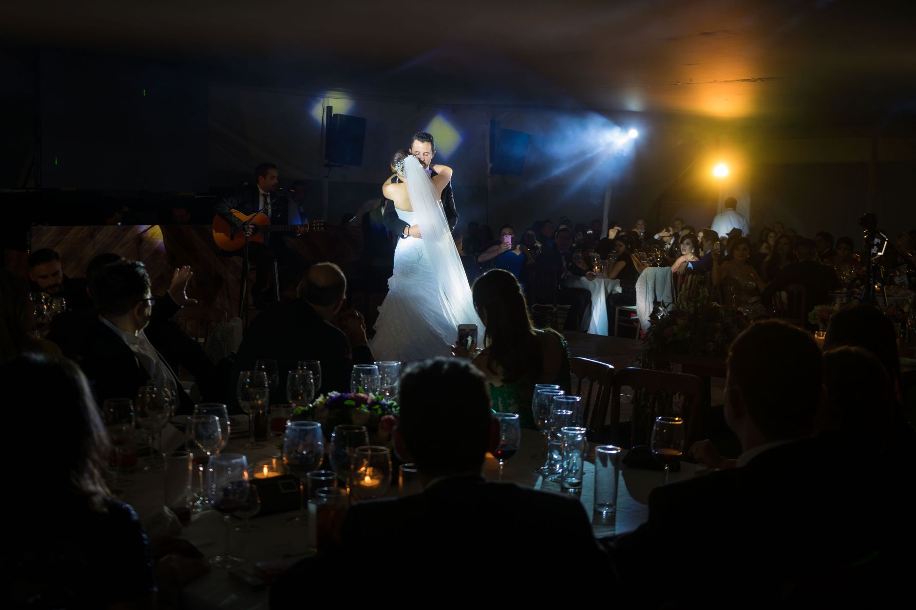 Salão de casamento em quinta iluminado por velas e luzes quentes durante a festa à noite