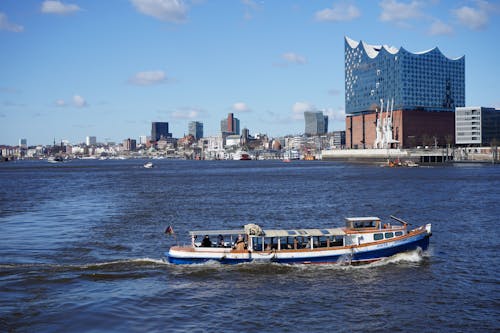 A White and Blue Boat with Passengers Travelling on Sea 