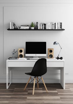 Minimalist home office with computer, bookshelf, and modern decor for a clean workspace.