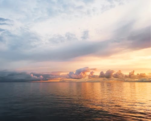 Body of Water Under Cloudy Sky