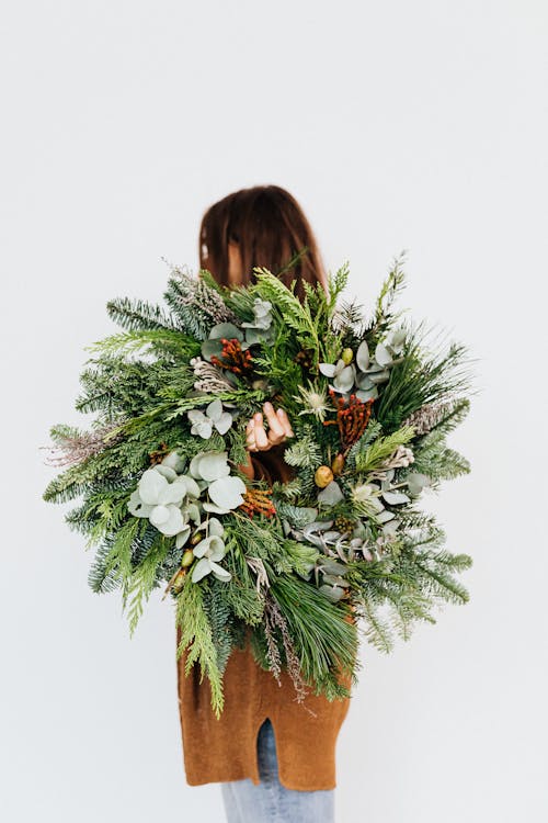 Woman Holding a Christmas Wreath Decoration