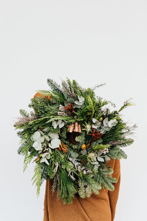 Person Holding a Christmas Wreath Decoration