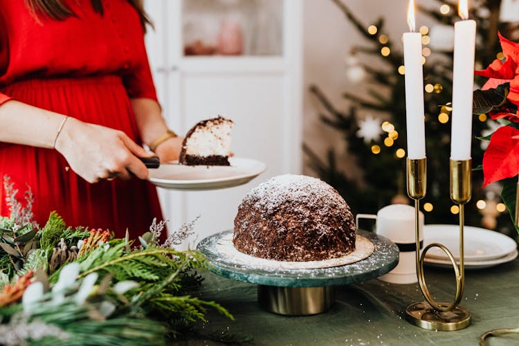 Woman Serving A Piece Of Cake On A Plate