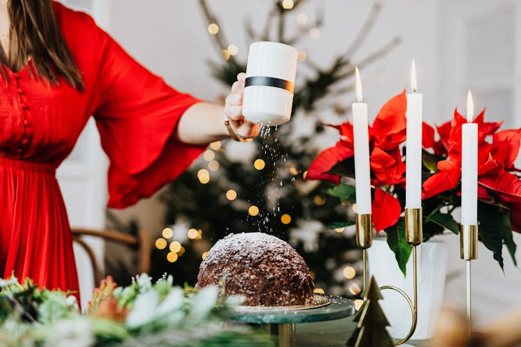 Woman Decorating A Chocolate Cake With Powdered Sugar