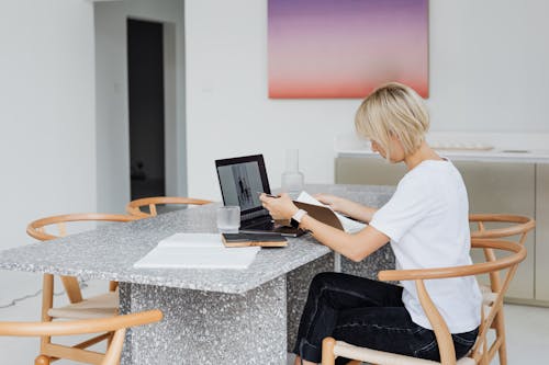 Woman in White Shirt and Black Pants Reading