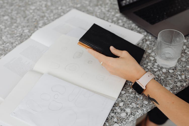 A Person Holding Black Booklet