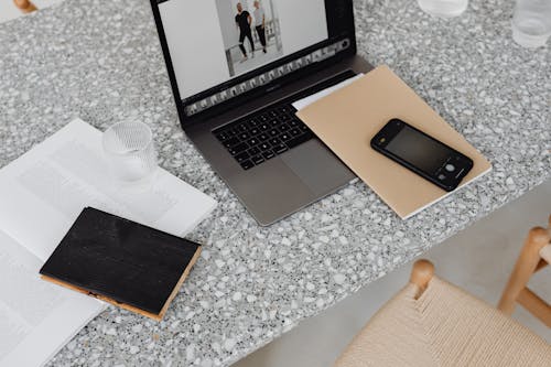 Brown Notebook on Top of Black and Gray Laptop