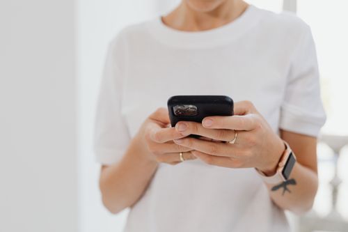 Free Adult using smartphone indoors, focusing on touchscreen communication. Stock Photo