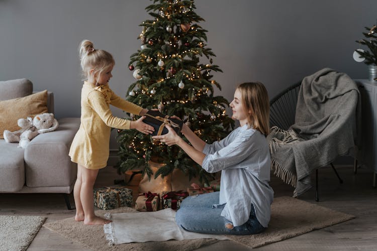 A Mother Handing Over A Gift To Her Child