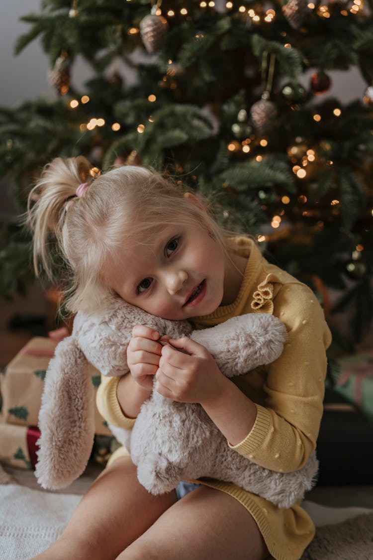 Girl In Yellow Long Sleeve Dress Hugging White Stuff Toy