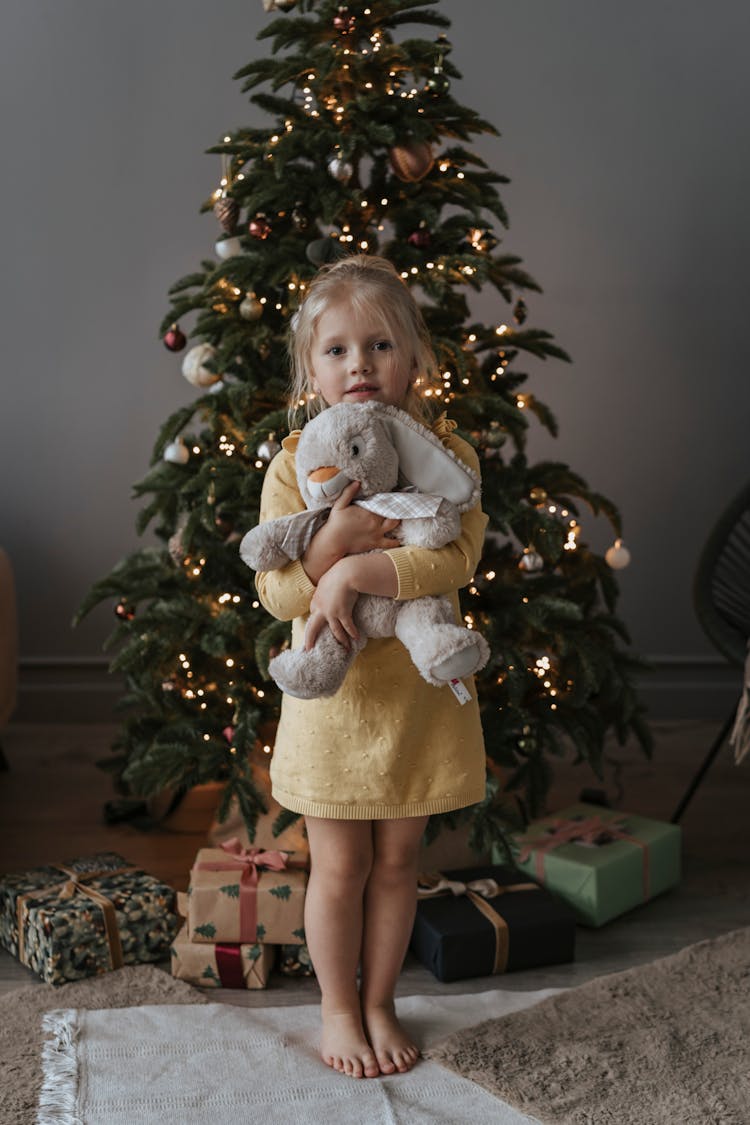 Blonde Girl In Yellow Dress Hugging A Stuffed Toy