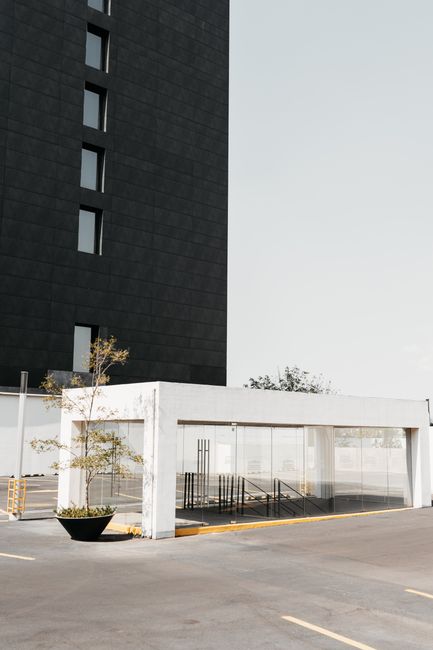Part of modern building near parking with entrance in underpass in sunny day
